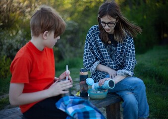 Boy and girl teenagers eating on a picnic in nature