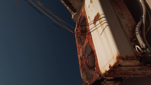 Old rusty air conditioner outdoors unit spinning in slow motion. Close up. High quality 4k footage