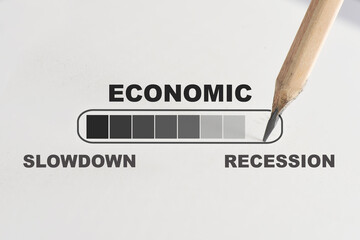 Economic slowdown to be recession loading written on white paper with pencil. Business cycle concept and challenge on bear market idea