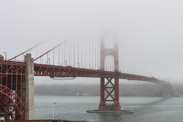 Obraz premium Golden Gate Bridge, San Francisco, USA-engineering masterpiece, art deco steel construction in orange with details such as lighting, outlining the cables and towers appearing out of the vanishing fog