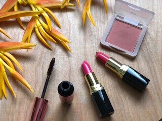 Set of makeup,cosmetics,Red matte lipstick and beautiful Heliconia flowers bouquet on wood...