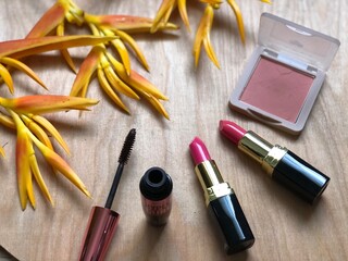 Set of makeup,cosmetics,Red matte lipstick and beautiful Heliconia flowers bouquet on wood...