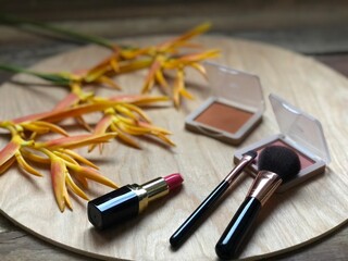 Set of makeup,cosmetics,Red matte lipstick and beautiful Heliconia flowers bouquet on wood...