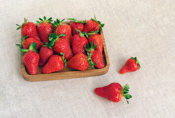 Strawberries on a wooden tray, top view. Bright berries on the table, healthy food.