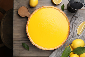 Delicious homemade lemon pie and fresh fruits on wooden table, flat lay