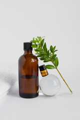 glass brown jars for oils on a background of white towels. transparent glass ball. Mockup beauty cosmetic products for skincare. Spa products.