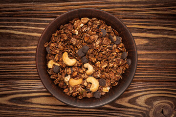 Chocolate granola cereal with nuts in a bowl.