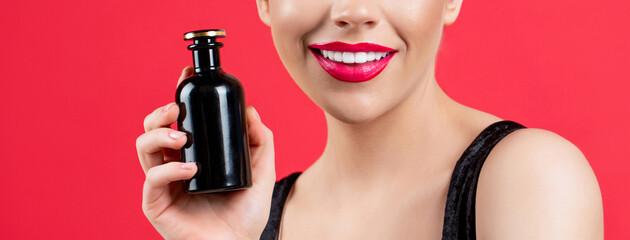 Beautiful girl using perfume. Woman with bottle of perfume. Woman presents perfumes fragrance. Woman perfumes bottle. Sexy lips. Red lip