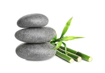 Stack of spa stones and bamboo stems on white background