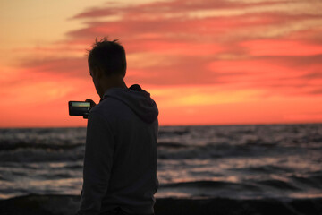 boy on a sea shore at a sunset