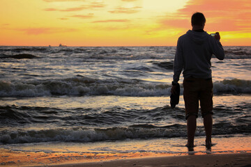 boy on a sea shore at a sunset