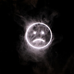 Stylized face expressing emotion glows through the stream of smoke in the dark