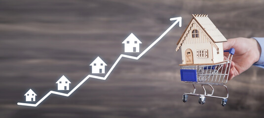Man holding house model with a arrow.
