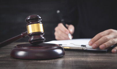 Judge gavel on the table. Judge signing document. Law concept