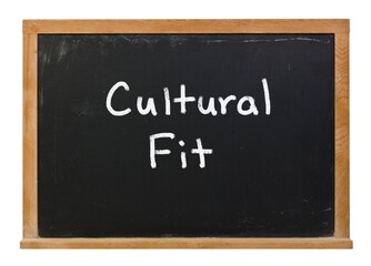 Obraz premium Cultural fit written in white chalk on a black chalkboard isolated on white
