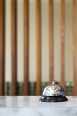 Silver service bell on hotel reception desk. Close up
