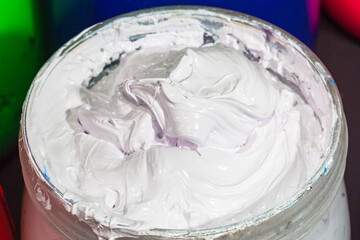 close up white color of ink for print tee shirt in the glass bucket..colorful of white ink background..