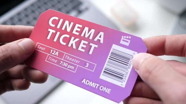 Holding a cinema ticket on the hands. Theater admission ticket with bar code.