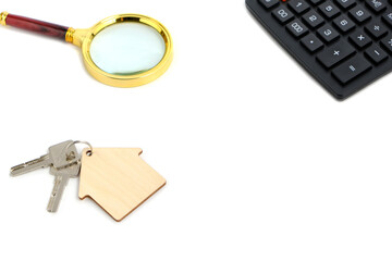 Calculator,magnifier and house keys.Concept of buying and selling housing, mortgages and renting a house or apartment.