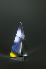 bunte Lichterscheinungen in einem beleuchteten Prisma aus Glas auf schwarzem Hintergrund