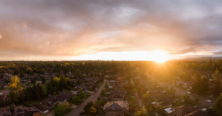 Aerial panoramic view of a suburban neighborhood during a vibrant and colorful sunset. Taken in Greater Vancouver, British Columbia, Canada.