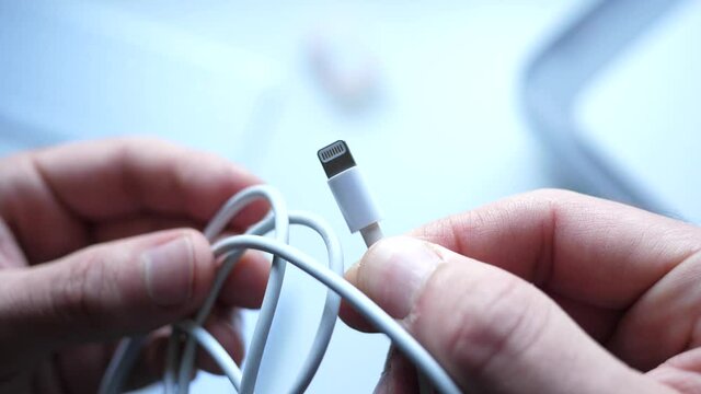 Holding an Apple lightning cable closeup shot.