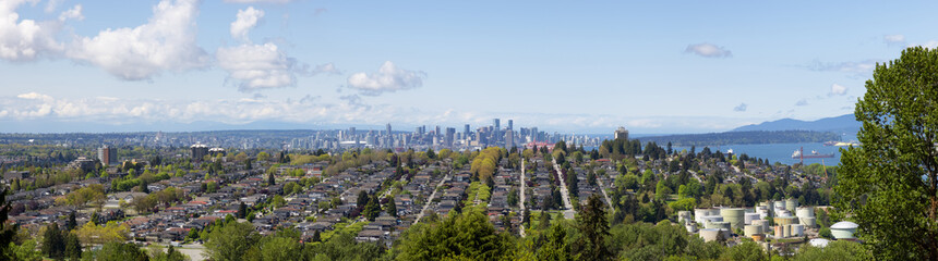 Obraz premium View of residential homes in suburban area of a modern city and Urban Downtown buildings in background. Vancouver, British Columbia, Canada.