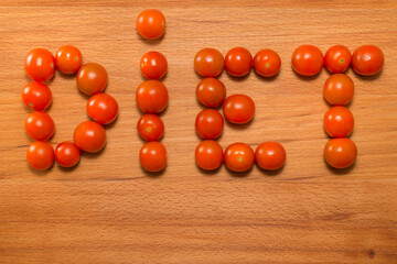 Tomatoes on a wooden table. Tomatoes form the word 