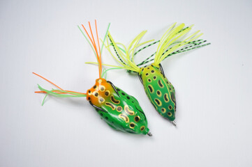 Fishing hook with a bayman in the shape of a frog. Fishing bait on white background. Male Hobbies...