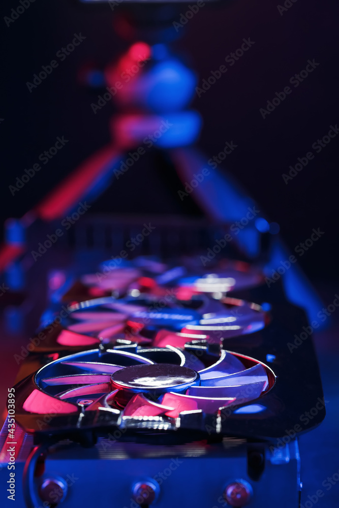 Poster a graphics card with a row of fans with a cyanotic purple backlight in a futuristic design.