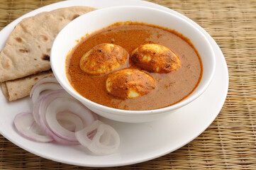 egg curry with chappati or roti, onion. Indian lunch.