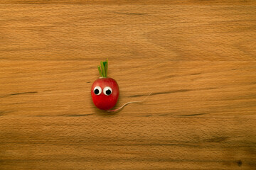 Mr. radish on wooden table. Close-up view from above