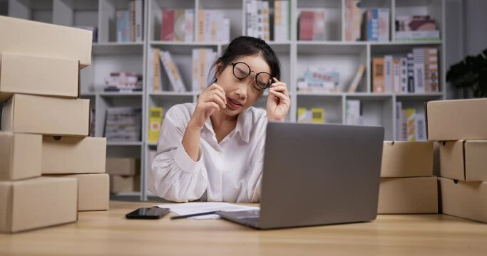 Asian working woman bored typing laptop at night.
