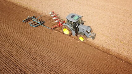 Traktor bearbeitet Acker mit Pflug und Grubber, Saatbettbereitung, Landwirtschaft aus der Vogelperspektive © keBu.Medien