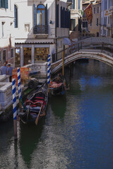 Fototapeta na wymiar gondolas moored by the canal facing facade of the narrow streets of the old city of Venice