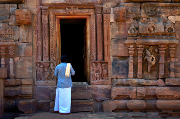 Naklejka premium Hampi, Karnataka, India - January 25 2020: An Indian man prays at a Temple at Hampi, Karnataka, India