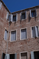 Fototapeta na wymiar facades with blue wooden shutters of the narrow streets of the old city of Venice