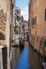 romantic idyllic view of gondola passing by the narrow canal street and renaissance facades of the city of Venice