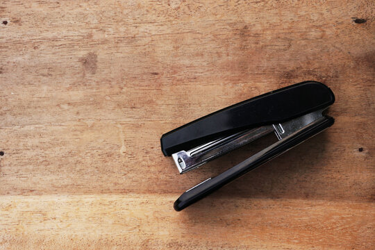 black stapler on the wood table