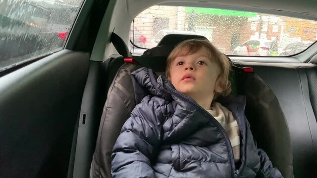 Baby Boy Waiting In The Car Sitting In Child Carseat Showing Patience