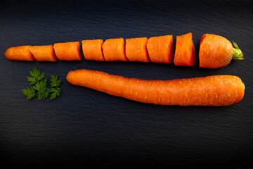 carota sezionata e intera con prezzemolo