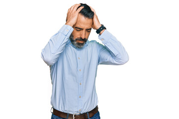 Middle aged man with beard wearing business shirt suffering from headache desperate and stressed because pain and migraine. hands on head.