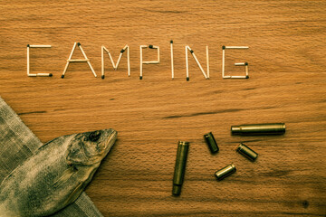 Matches and a piece of canvas with stockfish and shells are scattered on a wooden table. Matches...