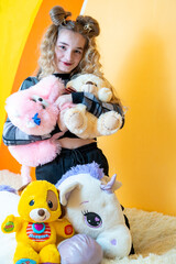 Young girl on the bed with soft toys