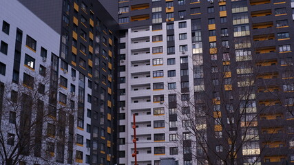 Fototapeta na wymiar Part of a modern building. The building is from the courtyard side. High-rise building, many windows, balconies. Apartment building.