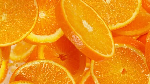 Super Slow Motion Shot of Flying Fresh Orange Slices Towards Camera at 1000 fps.