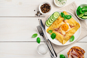 Breakfast with pancake, egg, ham and cheese on a white background. Breton crepe with basil. Horizontal view, copy space. - obrazy, fototapety, plakaty