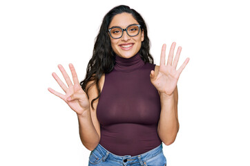 Brunette young woman wearing casual clothes and glasses showing and pointing up with fingers number...