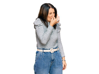 Fototapeta premium Middle age brunette woman wearing casual clothes smelling something stinky and disgusting, intolerable smell, holding breath with fingers on nose. bad smell