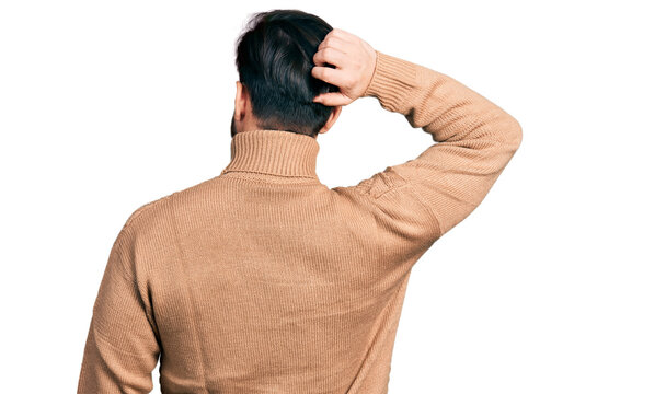 Young hispanic man wearing casual clothes backwards thinking about doubt with hand on head